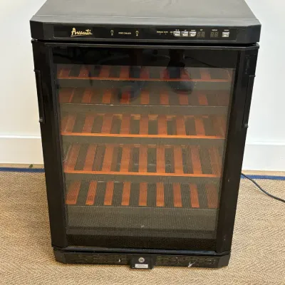 Sale Photo Thumbnail #45: Avanti freestanding wine chiller with a black exterior, glass door, and wooden slide-out shelves.