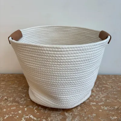 Sale Photo Thumbnail #165: Modern white coiled cotton rope storage basket featuring brown faux leather handles, in excellent condition.