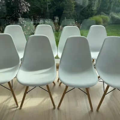 Sale Photo Thumbnail #22: Set of eight mid-century modern style molded plastic dining chairs in white, featuring wooden dowel legs with black wire bracing.