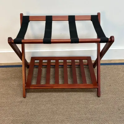 Sale Photo Thumbnail #143: Folding wooden luggage rack with a cherry finish, featuring four black fabric straps and a lower slatted shelf for shoe storage.