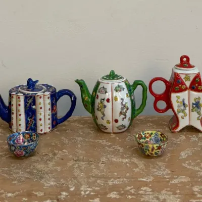 Sale Photo Thumbnail #107: Collection of five miniature Chinese porcelain teapots in various shapes and vibrant colors, accompanied by two small matching teacups.
