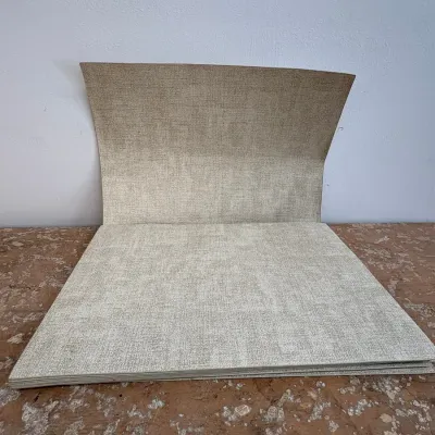 Sale Photo Thumbnail #153: Stack of square vinyl placemats with a textured, linen-like pattern in a neutral beige tone.