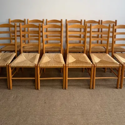 Sale Photo Thumbnail #47: Set of twelve vintage oak ladder-back dining chairs featuring woven rush seats and simple turned legs.
