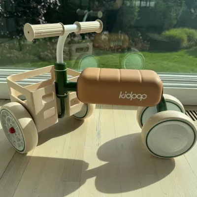 Sale Photo Thumbnail #27: Kidpop toddler balance bike featuring a green metal frame, tan padded seat, and a front-mounted plastic basket.