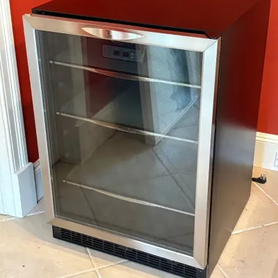 Sale Photo Thumbnail #173: Modern under-counter beverage cooler featuring a stainless steel trimmed glass door, black cabinet, and adjustable wire shelving.
