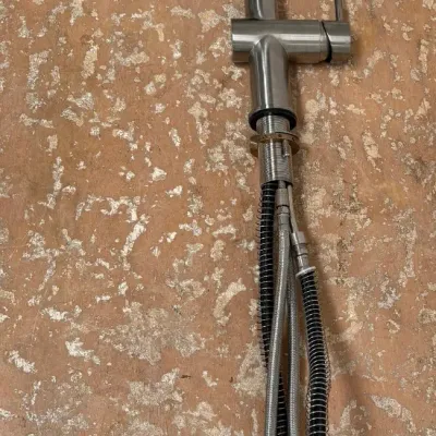 Sale Photo Thumbnail #157: Modern brushed nickel single-handle kitchen faucet with a high-arc spring spout and pull-down sprayer.