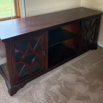 Sale Photo Thumbnail #51: Dark wood media console featuring two glass-front cabinets with decorative starburst overlays and an open center shelving section.