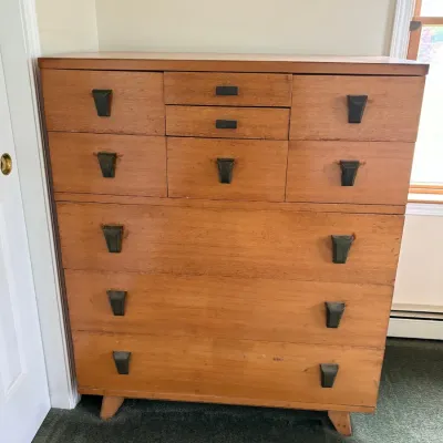 Sale Photo Thumbnail #55: Mid-century modern tallboy dresser in a warm wood finish, featuring a unique multi-drawer configuration with distinctive dark metal pulls.
