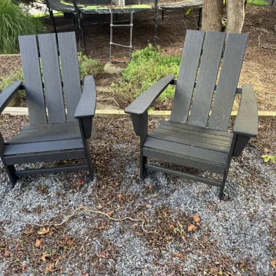 Sale Photo Thumbnail #3: Pair of dark gray composite Adirondack chairs, showing light outdoor wear.