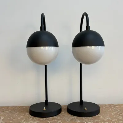 Sale Photo Thumbnail #41: Pair of mid-century modern style table lamps featuring matte black metal bases and stems with spherical white glass globes.