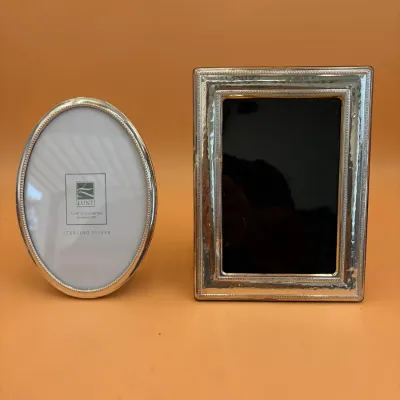 Sale Photo Thumbnail #62: Two sterling silver picture frames, including an oval Lunt Silversmiths frame with beaded trim and a rectangular frame with a hammered texture.