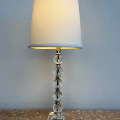 Sale Photo Thumbnail #109: Mid-century modern table lamp featuring a stacked clear acrylic sphere stem with brass accents and a simple white drum shade.