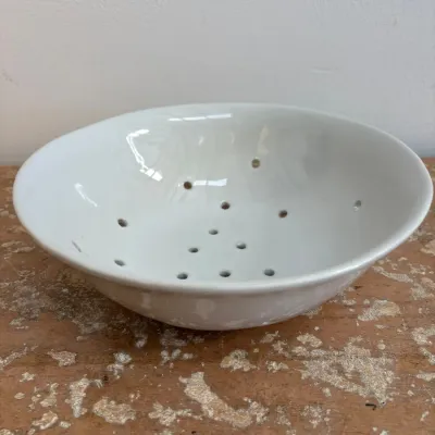 Sale Photo Thumbnail #117: White ceramic berry bowl or colander with drainage holes, featuring a glossy glaze finish.