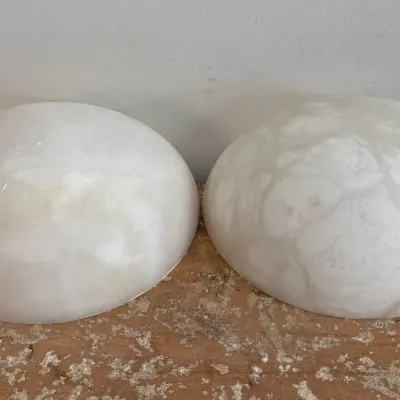 Sale Photo Thumbnail #124: Pair of vintage alabaster half-dome wall sconce shades, showing natural veining and a smooth, polished finish.