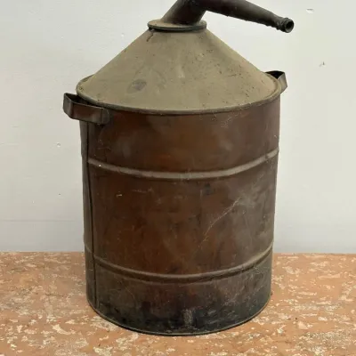 Sale Photo Thumbnail #171: Vintage metal oil or kerosene can with a conical top, angled spout, and side handles, showing a heavily weathered and rusted patina.