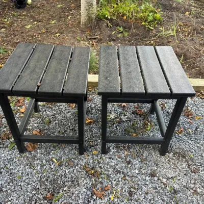 Sale Photo Thumbnail #5: Pair of black composite Adirondack-style side tables, showing some outdoor weathering.