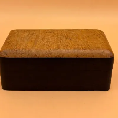 Sale Photo Thumbnail #61: Two-tone wooden keepsake box featuring a burl wood lid with rounded edges and a dark-stained base.