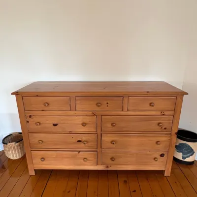 Sale Photo Thumbnail #48: Rustic pine double dresser featuring nine drawers with wooden knob pulls, showcasing natural wood grain and knots.