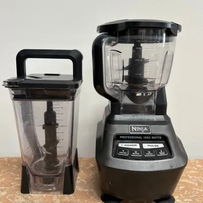 Sale Photo Thumbnail #151: Ninja Professional 1500 Watts blender system, including the motorized base, a round pitcher with blade assembly, and an additional square pitcher.