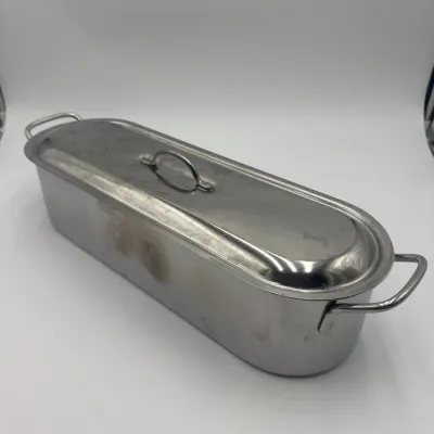 Sale Photo Thumbnail #98: Vintage stainless steel fish poacher with lid and side handles, showing some light surface wear and discoloration.