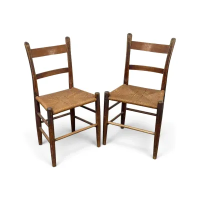 Sale Photo Thumbnail #147: Pair of antique ladder-back side chairs with woven rush seats and a distressed dark wood finish.