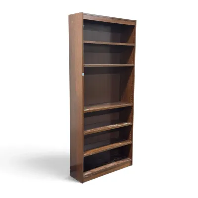Sale Photo Thumbnail #270: Mid-century modern style tall wooden bookcase with adjustable shelves, showing some wear and scuffs on the lower shelves.