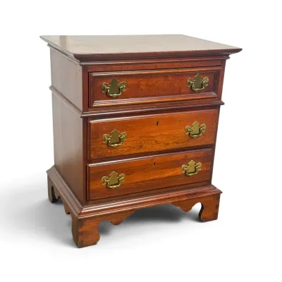 Sale Photo Thumbnail #60: Chippendale-style cherry wood nightstand featuring three drawers with brass batwing pulls and bracket feet.