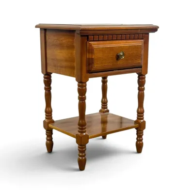 Sale Photo Thumbnail #11: Traditional cherry wood nightstand featuring a single drawer with a brass pull, dentil molding detail, turned legs, and a lower display shelf.