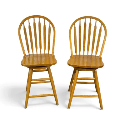 Sale Photo Thumbnail #91: Pair of vintage oak Windsor-style swivel bar stools with arrow-back spindles and contoured seats.