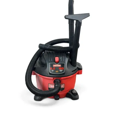 Sale Photo Thumbnail #130: Craftsman 5.0 peak horsepower wet/dry shop vacuum, featuring a red and black plastic body, flexible hose, and two attachment nozzles.