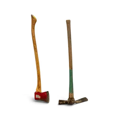 Sale Photo Thumbnail #248: Vintage single-bit felling axe with a red-painted head and curved wooden handle, paired with a vintage pick mattock featuring a green-painted accent on its wooden handle.
