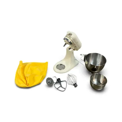 Sale Photo Thumbnail #105: Vintage cream-colored KitchenAid stand mixer, model K45, complete with two stainless steel mixing bowls, three attachments, and a yellow fabric dust cover.