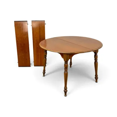 Sale Photo Thumbnail #146: Vintage round wooden dining table with turned legs, shown with two matching extension leaves.