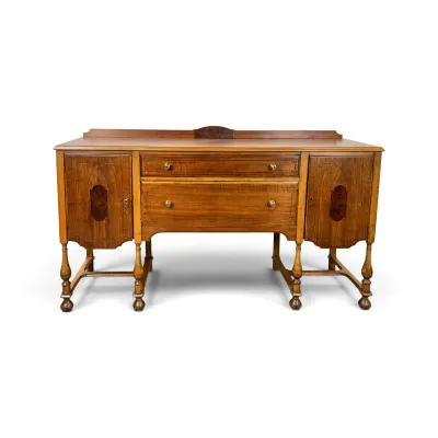 Sale Photo Thumbnail #140: Antique Jacobean Revival style wooden sideboard, featuring two central drawers flanked by side cabinets, turned legs, and decorative wood inlays.