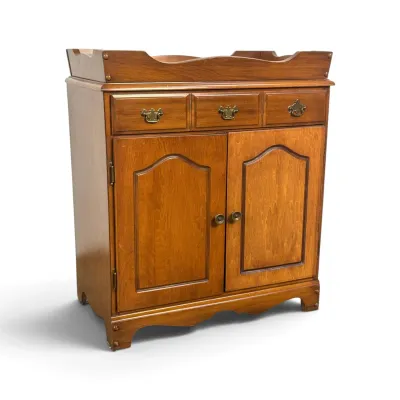 Sale Photo Thumbnail #94: Vintage Ethan Allen maple dry sink cabinet, featuring three top drawers with brass batwing pulls and a two-door lower storage compartment.