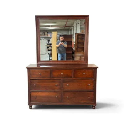 Sale Photo Thumbnail #264: Traditional cherry wood seven-drawer dresser with matching landscape mirror, featuring turned feet and round metal pulls.