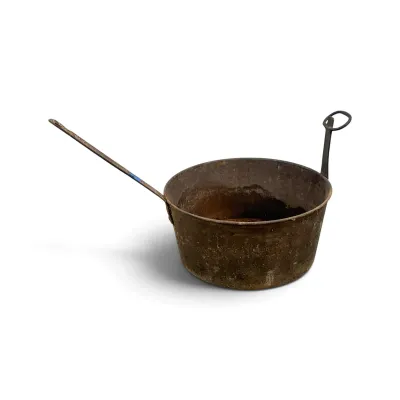 Sale Photo Thumbnail #121: Antique rustic metal pot featuring a long straight handle on one side and a looped handle on the other, showing heavy patina and wear.