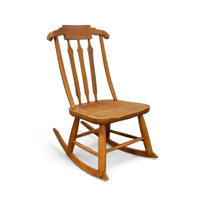 Sale Photo Thumbnail #204: Vintage wooden rocking chair featuring a high back with arrow splats and a contoured seat, showing some wear to the finish.