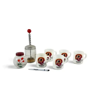 Sale Photo Thumbnail #37: Vintage kitchenware collection including five milk glass Washington Redskins mugs, a glass food chopper with a red knob, and a ceramic pepper shaker with a tulip design.