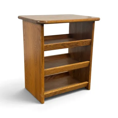 Sale Photo Thumbnail #109: Vintage oak media stand or record cabinet featuring three angled shelves with front lips, ideal for vinyl storage, circa late 20th century.