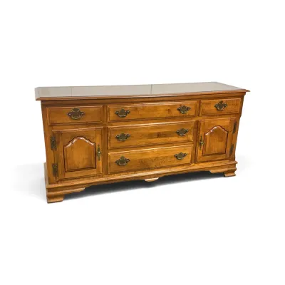 Sale Photo Thumbnail #101: Vintage Ethan Allen maple buffet credenza featuring a glass top, brass hardware, five drawers, and two side cabinets with arched panel doors.