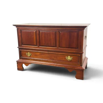 Sale Photo Thumbnail #59: Vintage cherry wood blanket chest featuring three raised panels, a single bottom drawer with brass batwing pulls, and bracket feet.