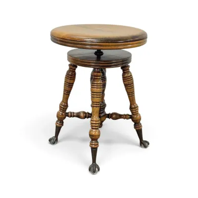 Sale Photo Thumbnail #183: Antique wooden piano stool featuring a swivel seat, turned legs, and glass ball-and-claw feet.