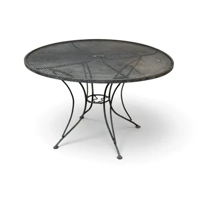Sale Photo Thumbnail #254: Vintage black wrought iron patio table featuring a round mesh top with an umbrella hole and curved legs.