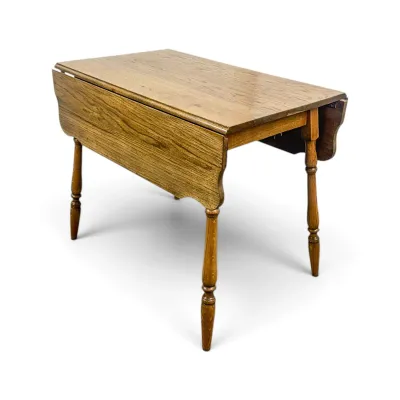 Sale Photo Thumbnail #58: Vintage oak drop-leaf table featuring turned legs and a warm honey finish, showing minor surface wear.