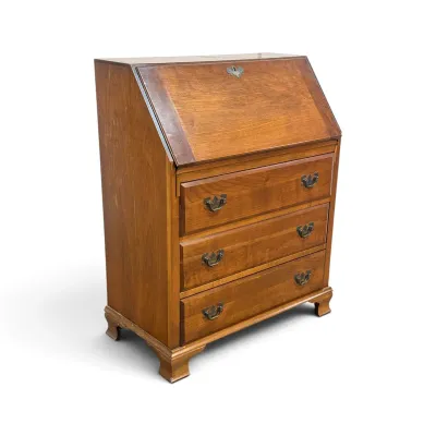 Sale Photo Thumbnail #119: Vintage cherry wood slant-front secretary desk featuring three drawers with brass batwing pulls and bracket feet.