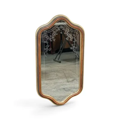 Sale Photo Thumbnail #319: Vintage wall mirror with an etched floral scroll design on the upper glass, set in a shaped wood frame with gold and reddish-brown finishes.