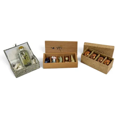 Sale Photo Thumbnail #43: Collection of Asian decorative items, including an inside-painted glass snuff bottle in a fabric-covered box, a set of five miniature ceramic figurines in a wooden box, and a set of four copper-toned openwork rings in a cardboard box.
