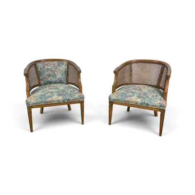 Sale Photo Thumbnail #71: Pair of vintage mid-century barrel back armchairs featuring woven cane backs, tapered wooden legs, and floral tapestry upholstery.