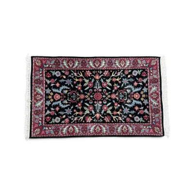 Sale Photo Thumbnail #288: Small Persian-style area rug featuring an intricate floral pattern on a black field with a burgundy border and white fringe.